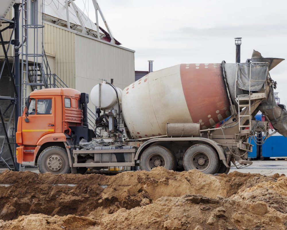 Concrete mixer truck loads concrete at the factory. Transportation of concrete to the construction site. Construction equipment for the delivery of concrete